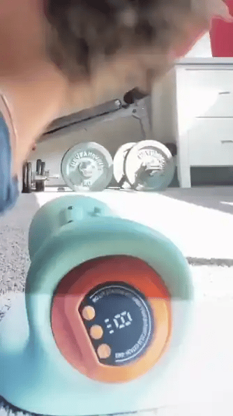 Clienta acostada usando el masajeador cervical